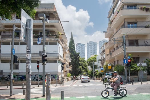 Tel Aviv, Israel - May 18, 2023: view from Rothschild Boulevard with bycicle rider to houses built in Bauhaus style, imported from german architects.