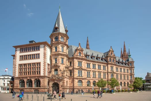 Wiesbaden, Germany - May 18, 2023: view from the market square to the old town hall of Wiesbaden with people enjoying the sunny day.