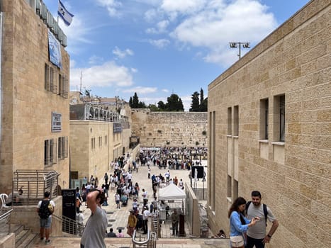 Jerusalem, Israel - May 19, 2023: people visit the most famous western wall at the old temple in Jerusalem. They pray at the wailing wall and put written foulded papers into the wall.