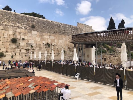 Jerusalem, Israel - May 19, 2023: Jewish worshipers are praying at the Wailing Wall in Jerusalem, Israel.