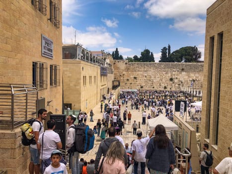 Jerusalem, Israel - May 19, 2023: people visit the most famous western wall at the old temple in Jerusalem. They pray at the wailing wall and put written foulded papers into the wall.