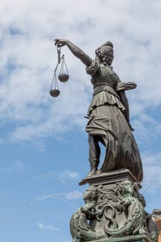 Frankfurt, Germany - May 24, 2023: lady justice in Frankfurt with sword and cloudy sky as symbol for justice and law