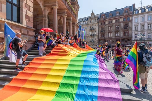 Wiesbaden, Germany - May 27, 2023: people enjoy the christopher street parade in Wiesbaden with rainbow flags and beaufiful costumes.