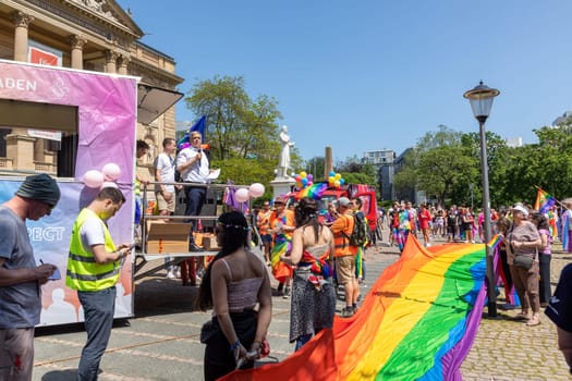 Wiesbaden, Germany - May 27, 2023: people enjoy the christopher street parade in Wiesbaden with rainbow flags and beaufiful costumes.
