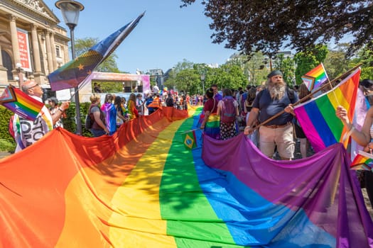 Wiesbaden, Germany - May 27, 2023: people enjoy the christopher street parade in Wiesbaden with rainbow flags and beaufiful costumes.