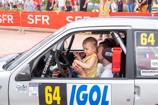 Geraldmer, France - June 18, 2023: rally driver with his child at the drivers position on the way to the official welcome greeting of the geraldmer rally trophy.