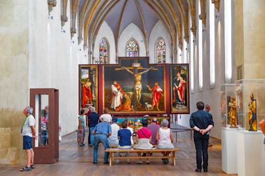 Colmar, France – June 21, 2023: people admire the Isenheim Altarpiece from sculpture Nikolaus Hagenauer and painter Matthias Gruenewald from 1512 to 1516.