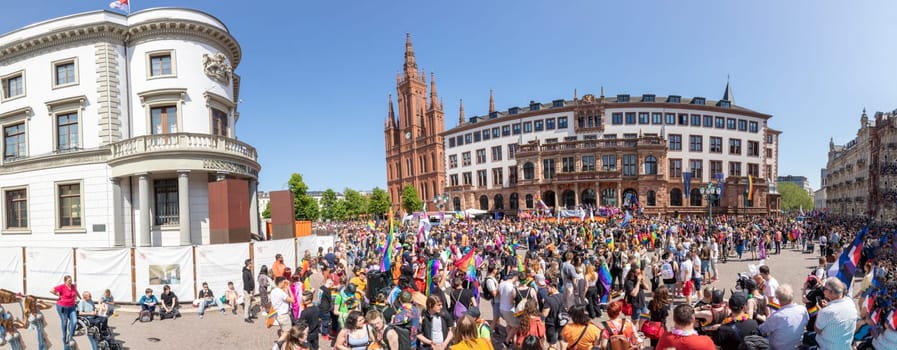 Wiesbaden, Germany - May 27, 2023: people enjoy the christopher street parade in Wiesbaden with rainbow flags and beaufiful costumes.