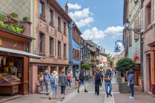 Ribeauville, France - June 23, 2023: A picturesque colorful street of half-timber buildings with shops and cafes in the village of Ribeauville, in the Alsace region.