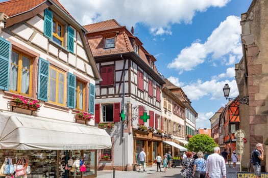 Ribeauville, France - June 23, 2023: A picturesque colorful street of half-timber buildings with shops and cafes in the village of Ribeauville, in the Alsace region.