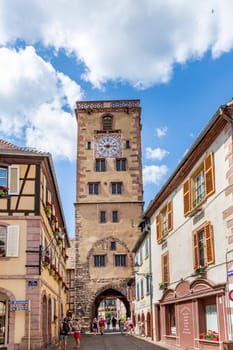 Ribeauville, France - June 23, 2023: A picturesque colorful street of half-timber buildings with shops and cafes in the village of Ribeauville, in the Alsace region.