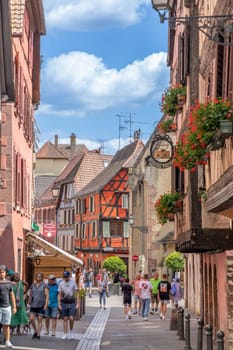 Ribeauville, France - June 23, 2023: A picturesque colorful street of half-timber buildings with shops and cafes in the village of Ribeauville, in the Alsace region.