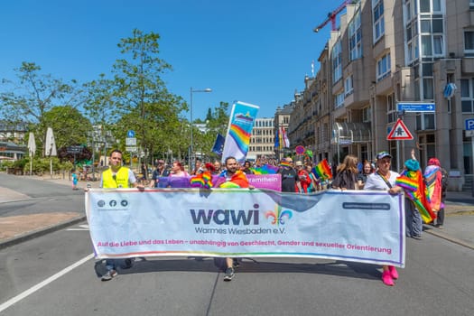 Wiesbaden, Germany - May 27, 2023: people enjoy the christopher street parade in Wiesbaden with rainbow flags and beaufiful costumes.