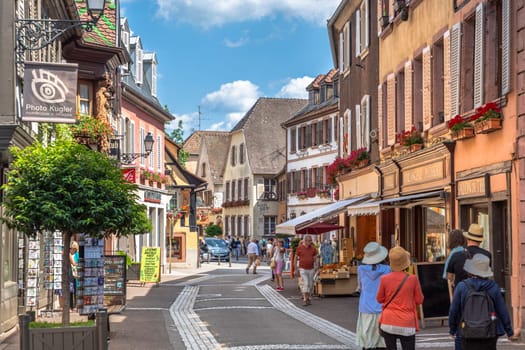 Ribeauville, France - June 23, 2023: A picturesque colorful street of half-timber buildings with shops and cafes in the village of Ribeauville, in the Alsace region.