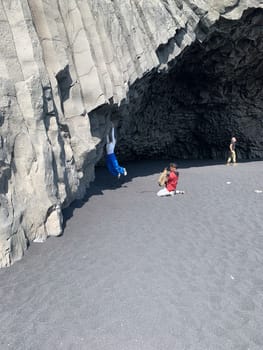 Reynisfjara, Icelang - July 19, 2023: people visit vertical basalt columns at Reynisfjara, the famous black beach in Iceland, near Vík í Mýrdal, form a perfect geometric background pattern