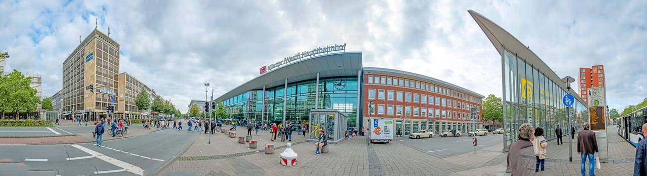 Muenster, Germany - August 5, 2023: people hurry to train station with its modern glass facade construction in Munster, Germany.