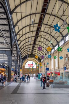 Wiesbaden, Germany - August 16, 2023:  people wait in the train station for departure in classicistic train station in Wiesbaden, the smaller copy of Frankfurt Train station.