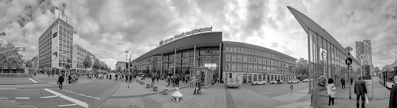 Muenster, Germany - August 5, 2023: people hurry to train station with its modern glass facade construction in Munster, Germany.