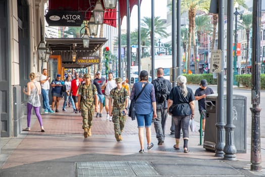 New Orleans, USA - October 24, 2023: people walk along the sidewalk. Two soldiers in uniform are walking at Canal street.