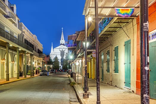 New Orleans  USA - October 24, 2023: Pubs and bars with neon lights in the French Quarter, downtown New Orleans by night with shadow of ghost at church wall
