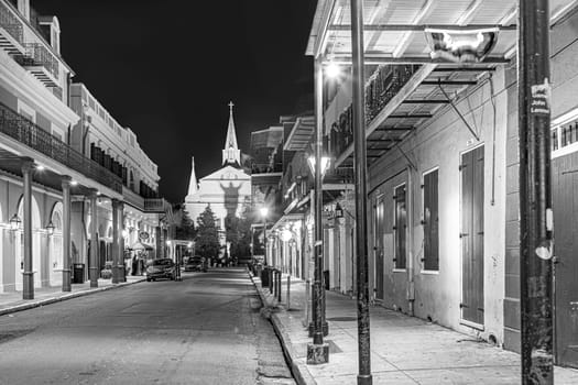 New Orleans  USA - October 24, 2023: Pubs and bars with neon lights in the French Quarter, downtown New Orleans by night with shadow of ghost at church wall