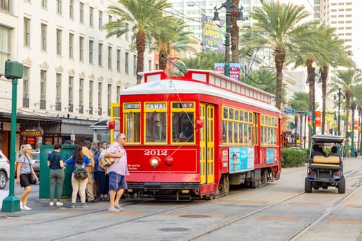New Orleans, USA - October 24, 2023: people enter the red street car  at Canal street in New Orleans.