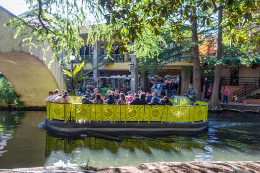 San Antonio, USA - October 31, 2023:  people enjoy the boat trip at  San Antonio River Walk. City park and pedestrian street in San Antonio, Texas. USA