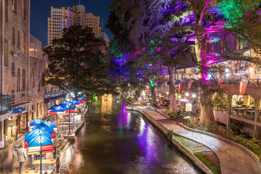 San Antonio, USA - October 31, 2023:  The San Antonio River Walk by night with illuminated trees and restaurants. City park and pedestrian street in San Antonio, Texas. USA