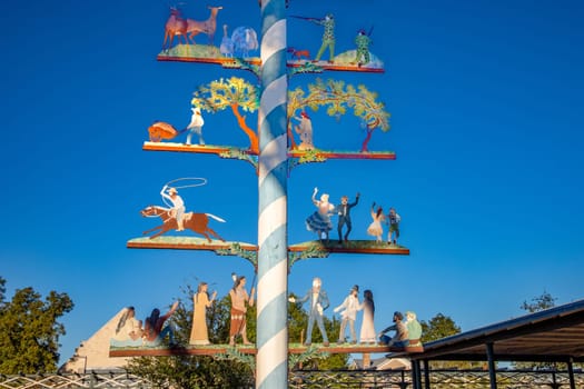 Fredericksburg, USA - November 1, 2023: maypole at market square in Fredericksburg, following the bavarian tradition with cowboys, indians, dancer, hunter and all the american former roles in the wild west, Texas, USA.