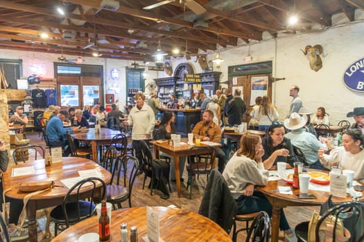 Fredericksburg, USA - November 1, 2023: people enjoy the western music performance in a food and bar saloon in Frederiksburg, Texas.