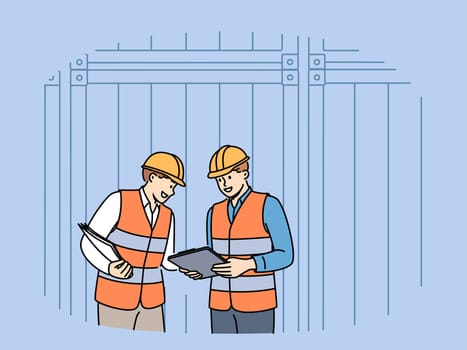 Men work in industrial field and stand near sea shipping containers discussing logistics or storage cargo. Teamwork of transport company employees dressed in industrial uniforms and hardhat