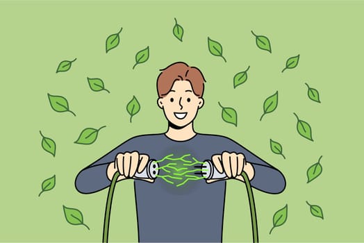 Man uses green energy obtained from environmentally friendly or alternative sources and connects two wires. Guy rejoices at receiving regenerative green energy to reduce co2 emissions