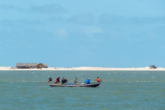 Atins, Brazil - December 23, 2023: people enjoy visiting by boat the lagoa bonita - beautiful sea in the desert dune landscape Lencois Maranhenses National Park - Parque Nacional dos Lencois Maranhenses