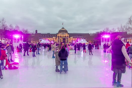 Wiesbaden, Germany - December 29, 2023: people enjoy the rink in front of the kurhaus in Wiesbaden, Hesse, germany.