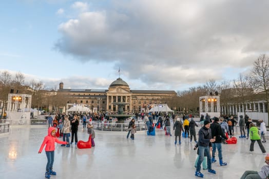Wiesbaden, Germany - December 29, 2023: people enjoy the rink in front of the kurhaus in Wiesbaden, Hesse, germany.