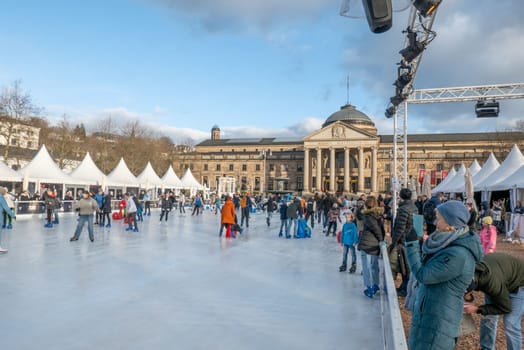Wiesbaden, Germany - December 29, 2023: people enjoy the rink in front of the kurhaus in Wiesbaden, Hesse, germany.