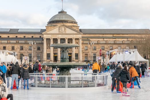 Wiesbaden, Germany - December 29, 2023: people enjoy the rink in front of the kurhaus in Wiesbaden, Hesse, germany.