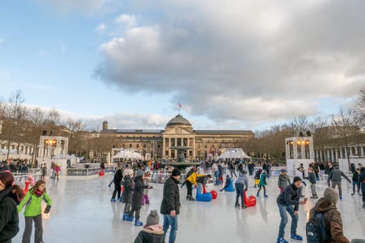 Wiesbaden, Germany - December 29, 2023: people enjoy the rink in front of the kurhaus in Wiesbaden, Hesse, germany.