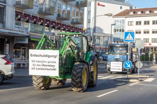 Wiesbaden, Germany - January 8, 2024: farmer with their tractors demonstrate for cutting down the price for diesel fuel and against the german government.with poster sorry, we fight for surviving.