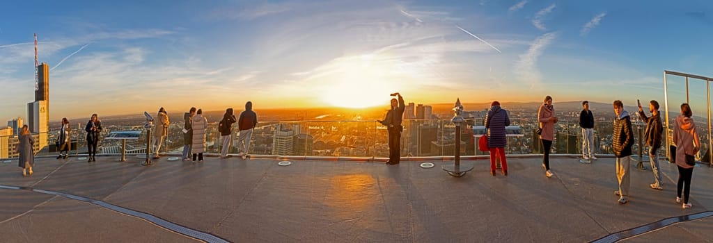 Frankfurt, Germany - February 1, 2024: people enjoy the scenic view to skyline of Frankfurt in dawn from Rhein Main tower.