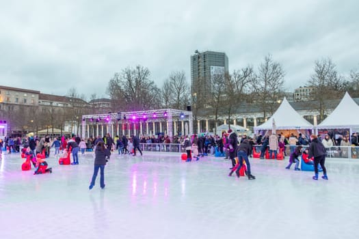Wiesbaden, Germany - December 29, 2023: people enjoy the rink in front of the kurhaus in Wiesbaden, Hesse, germany.