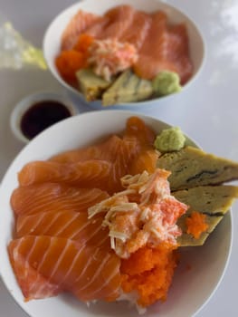 Salmon topped rice served with wasabi and soy sauce, stock photo