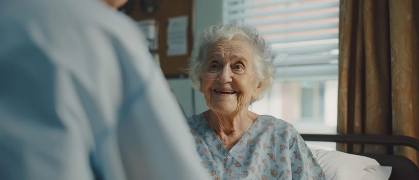 A senior woman's warm smile fills the hospital room as she chats with a caregiver, her spirit undiminished by her surroundings