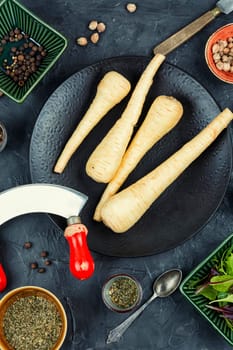 Raw parsnips roots and knife on the kitchen table