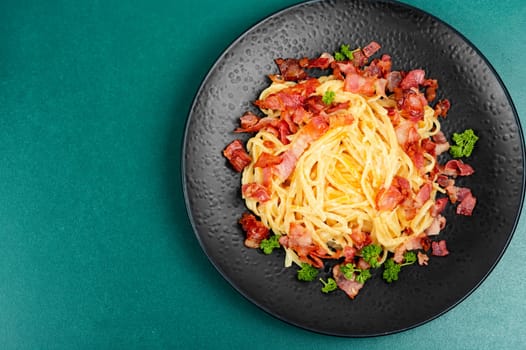Pasta or spaghetti carbonara with bacon and parmesan on a plate. Close up.