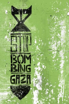 Graffiti on the green grungy wall depicting the silhouette of a bomb. Inside message: STOP BOMBING GAZA. Copy space. Fully editable.