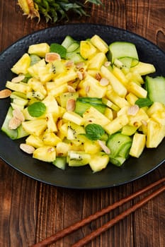 Asian vegan salad with pineapple, nuts and cucumber in a bowl. Weight loss concept.