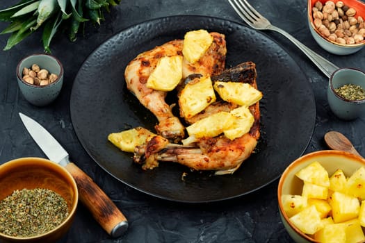 Chicken legs fried with pineapple pieces. Grilled chicken, grilled chicken legs on old wooden table.