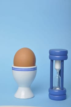 Boiled egg and hourglass on a blue background