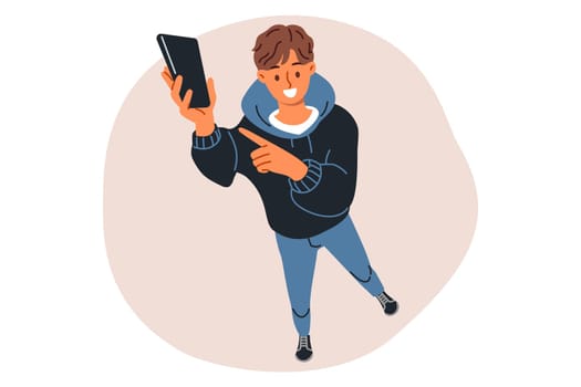 Mobile phone in hands teenage guy, holding gadget up and calling him to write SMS or add as friend on social networks. Fashionable teen boy showing off buying new cool phone with cool features
